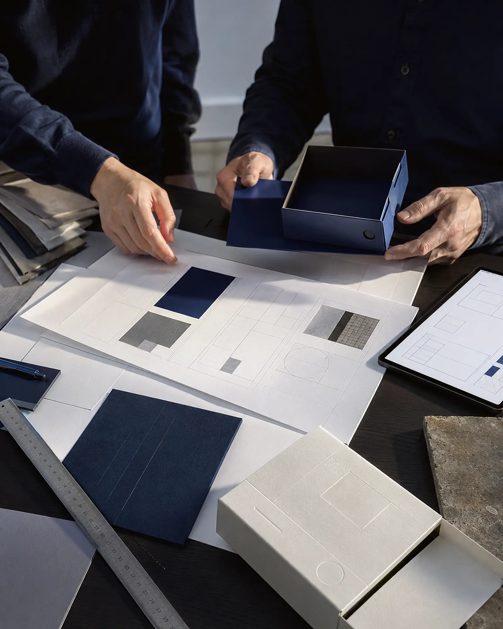 Hände bei der gemeinsamen Arbeit an Gestaltung, Material und Verpackung